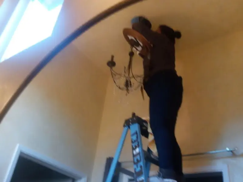 Electrician installing a chandelier in a Carefree residence